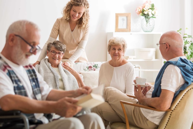 Group of senior friends sitting together at senior community living room