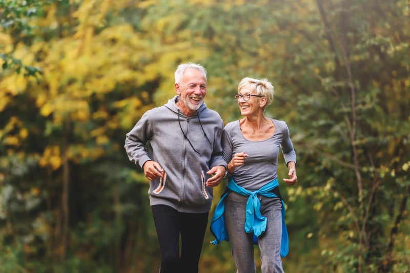 A smiling senior couple jogging in the park
