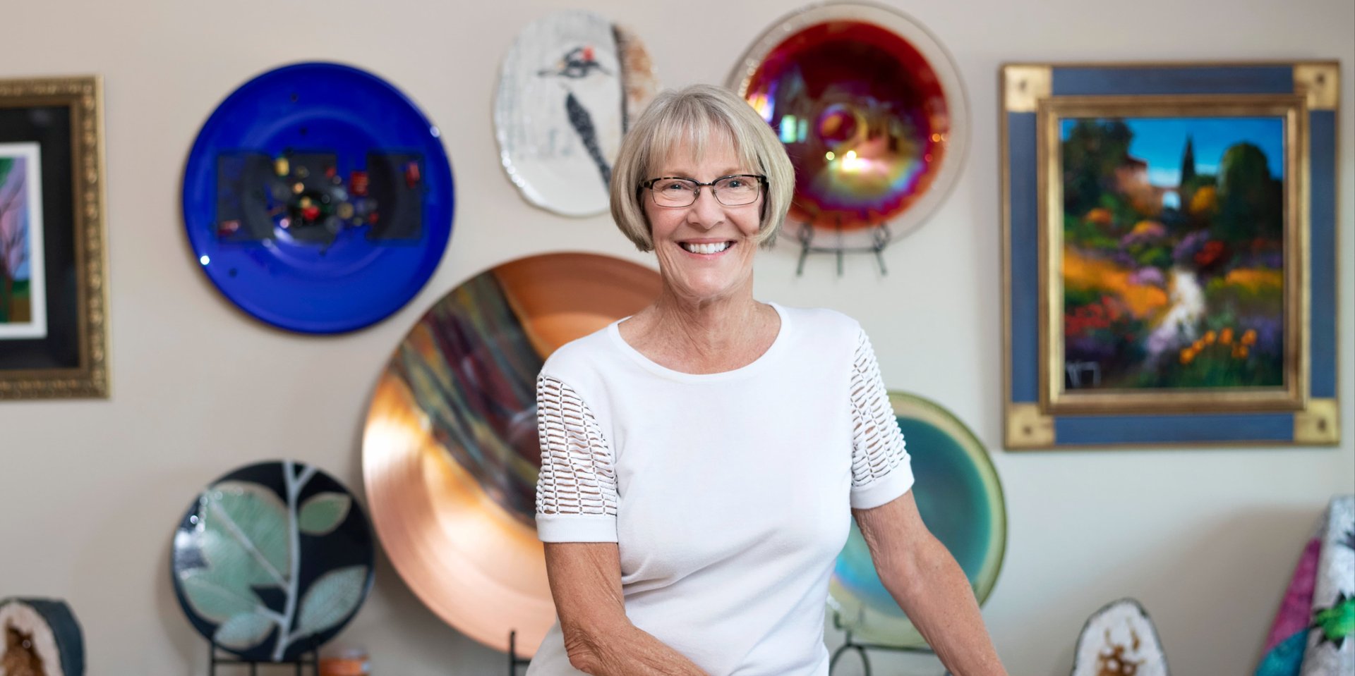 senior woman standing in front of crafts