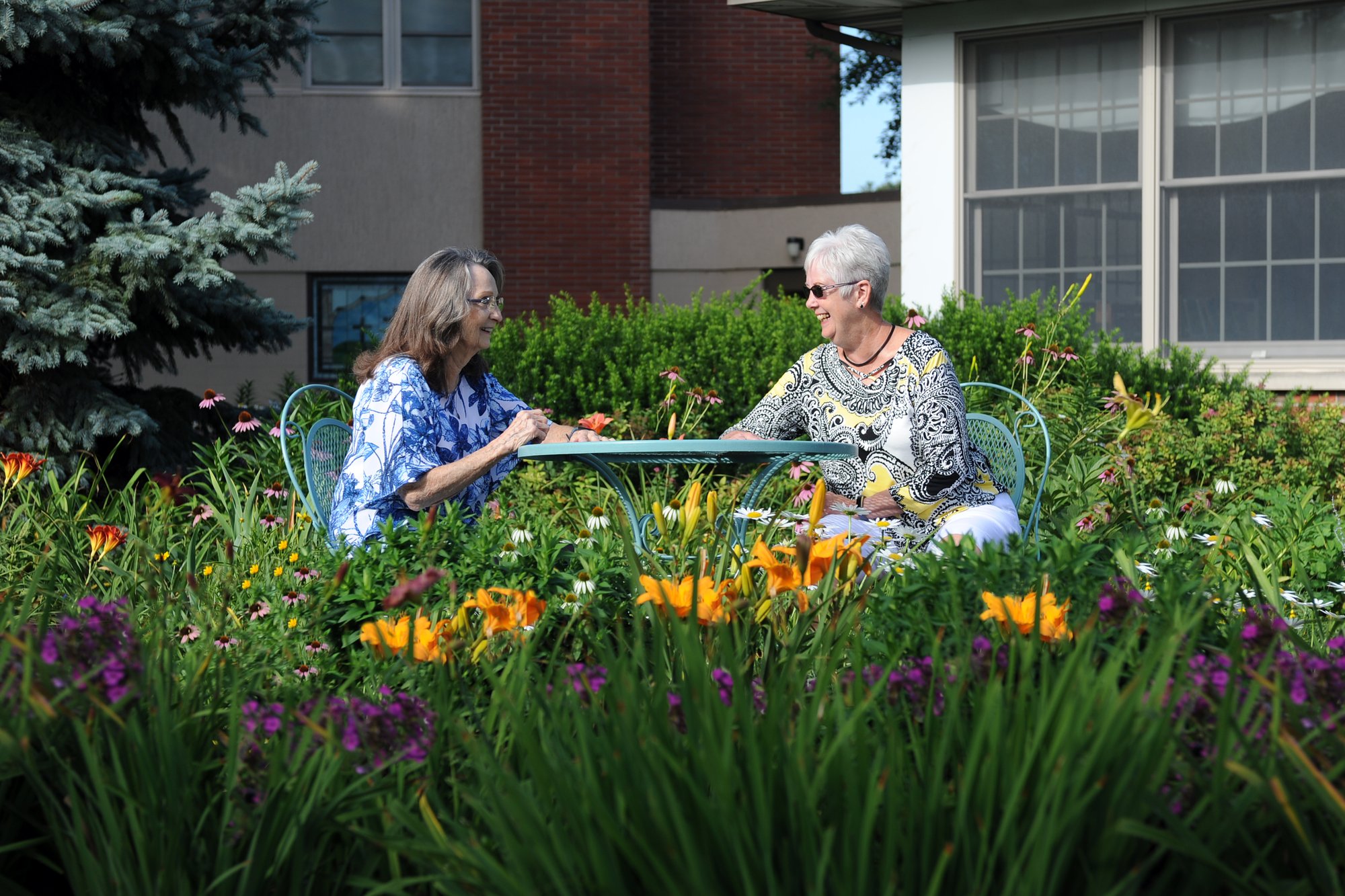 Ladies sitting at a table surrounded by flowers and greenery 