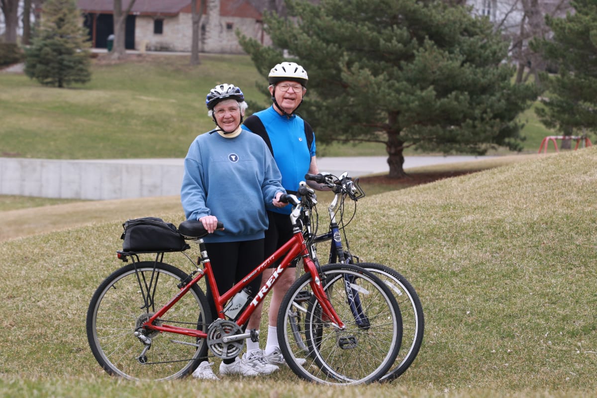 man and woman smiling next to bikes