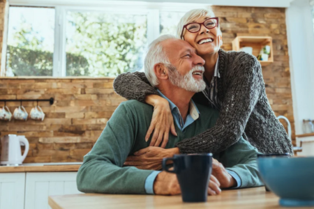 Senior woman smiling with senior husband in the kitchen