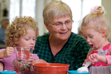 Senior woman smiling at two children