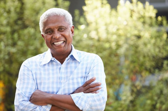 An older man smiling at the camera.