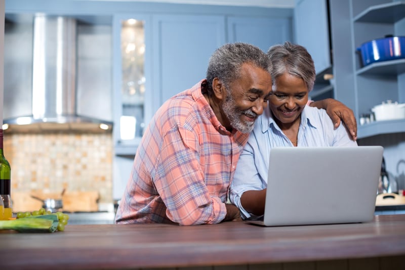 A senior couple using a laptop to plan for their future care.