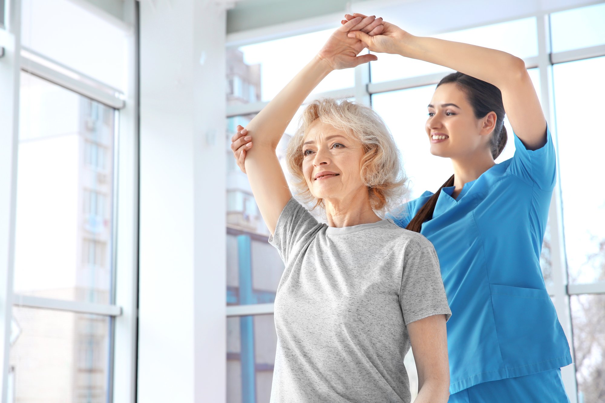caregiver and senior woman stretching