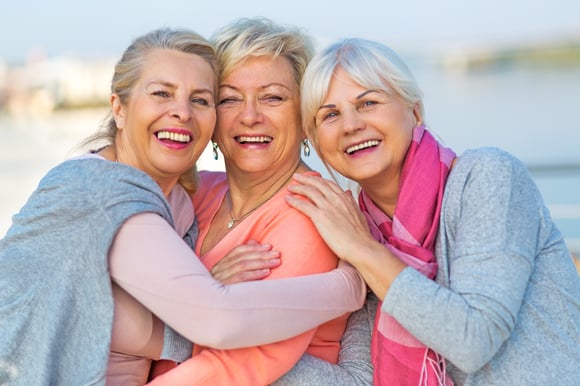 A group of senior ladies smiling at the camera.