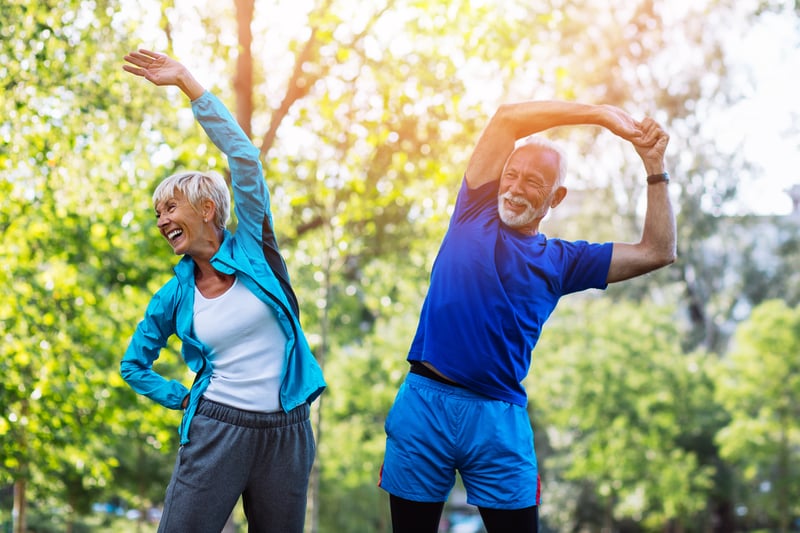 senior couple stretching in park