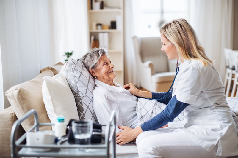 A hospice care professional examining a sick senior woman.