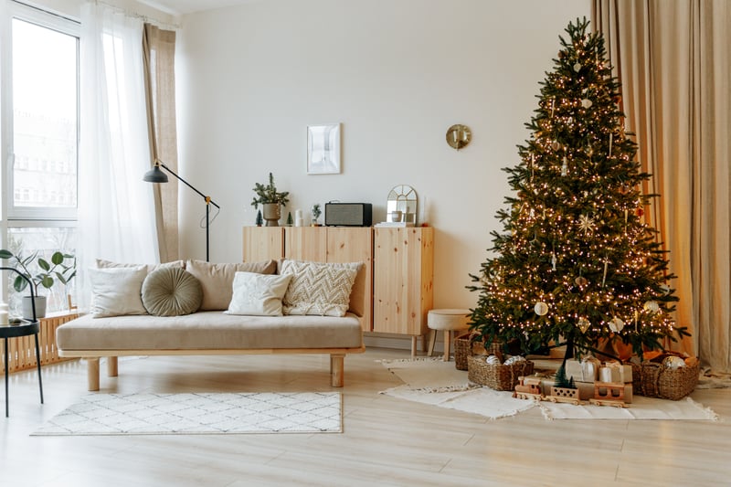 Bright interior of the living room with a sofa and a large Christmas tree.