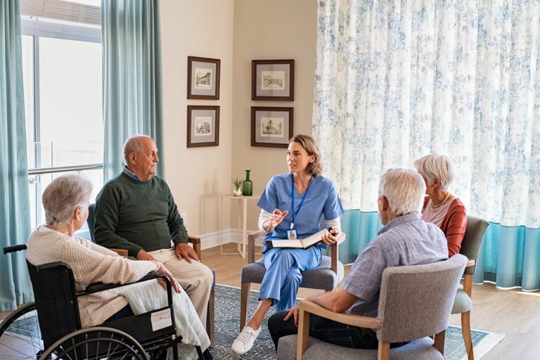 A group of older adults listening to a young nurse.