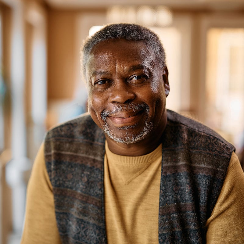 An older man smiling at the camera. 