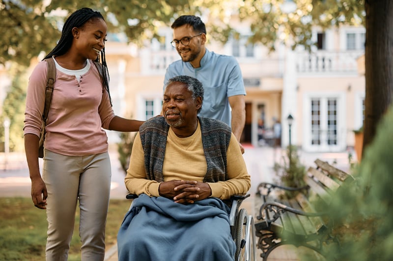 Son pushing smiling senior father in a wheelchair.