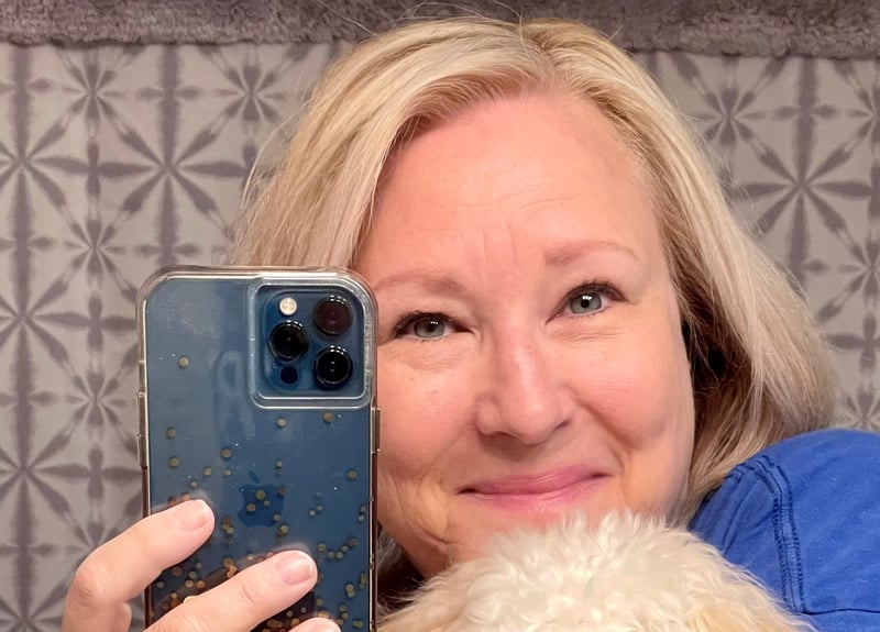 woman taking a mirror selfie with small dog