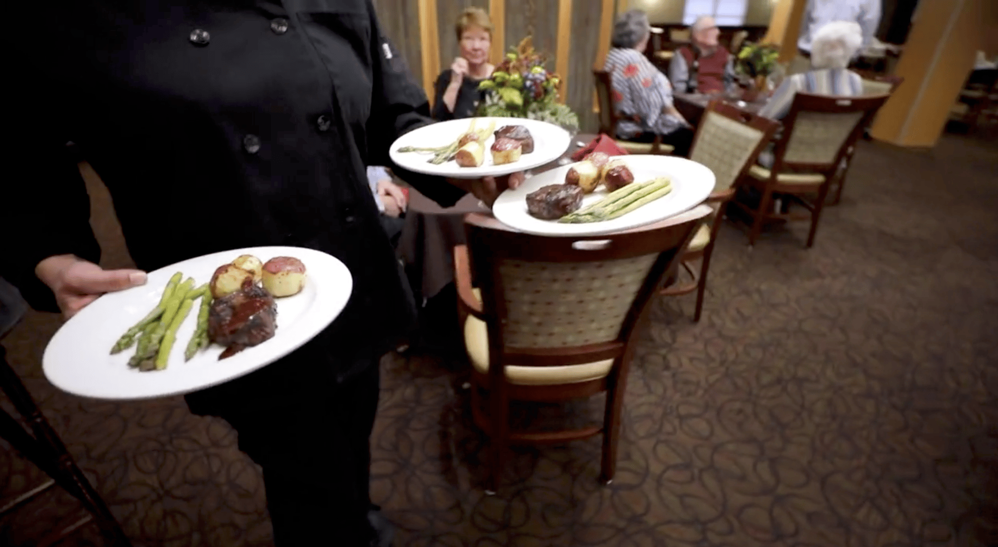 Waitress carrying plated meals