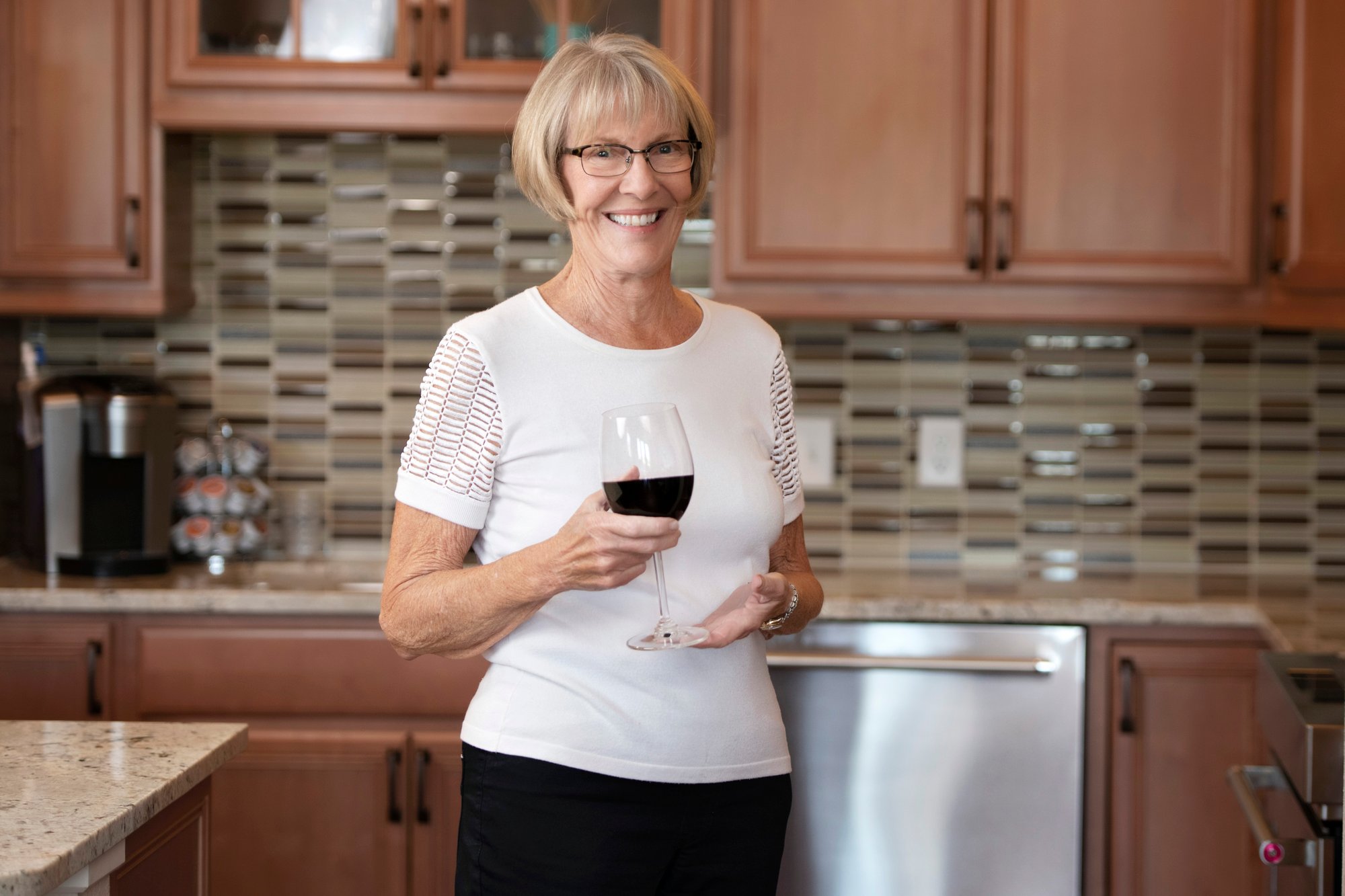 woman drinking wine in her kitchen