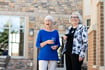 two women drinking wine outside