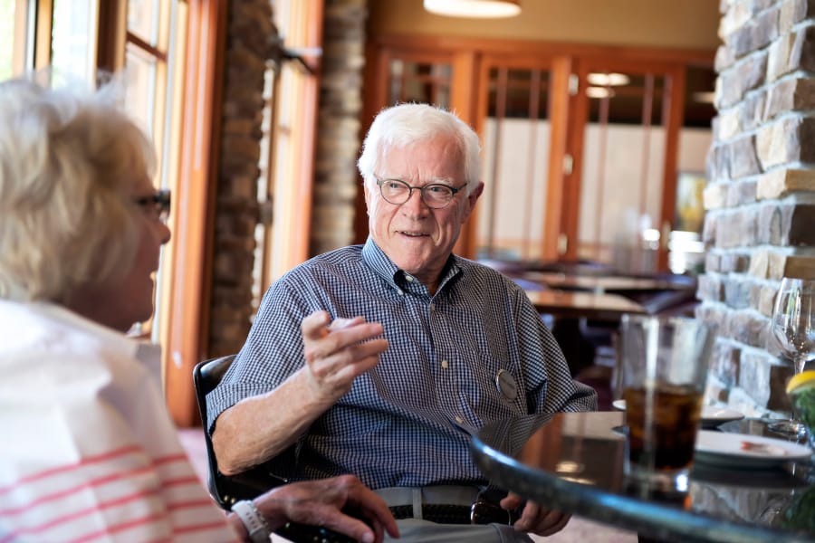 senior man talking to woman over lunch