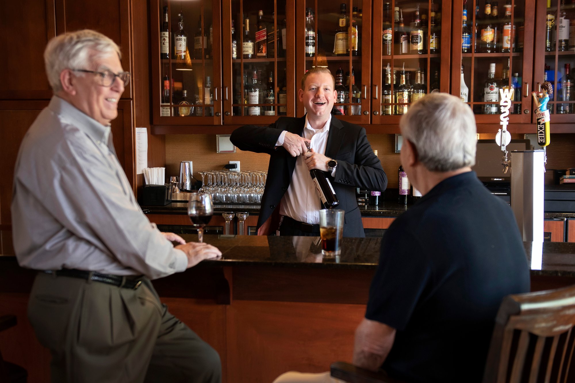 Older friends having a drink at a bar.