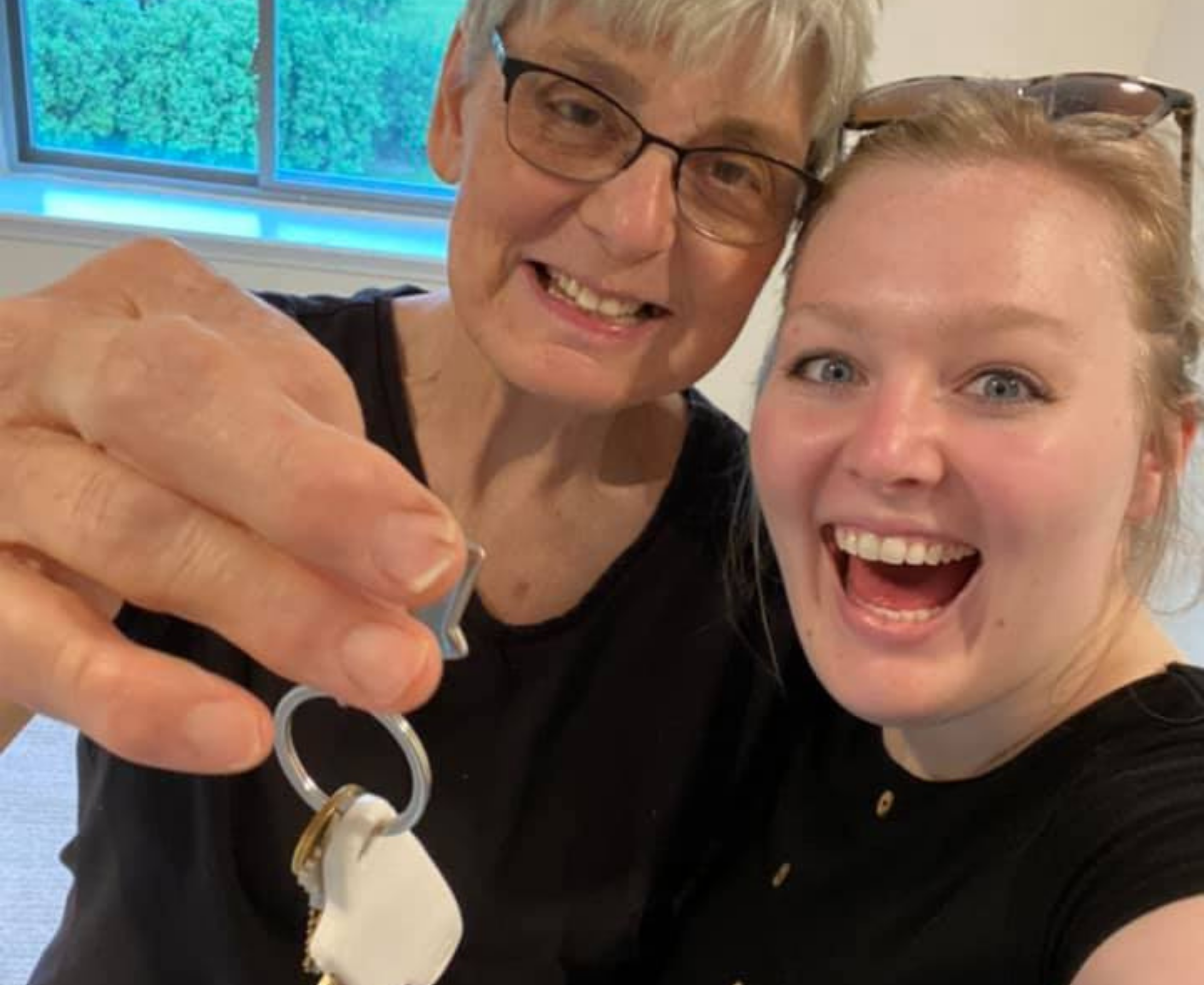 resident and employee smiling with key