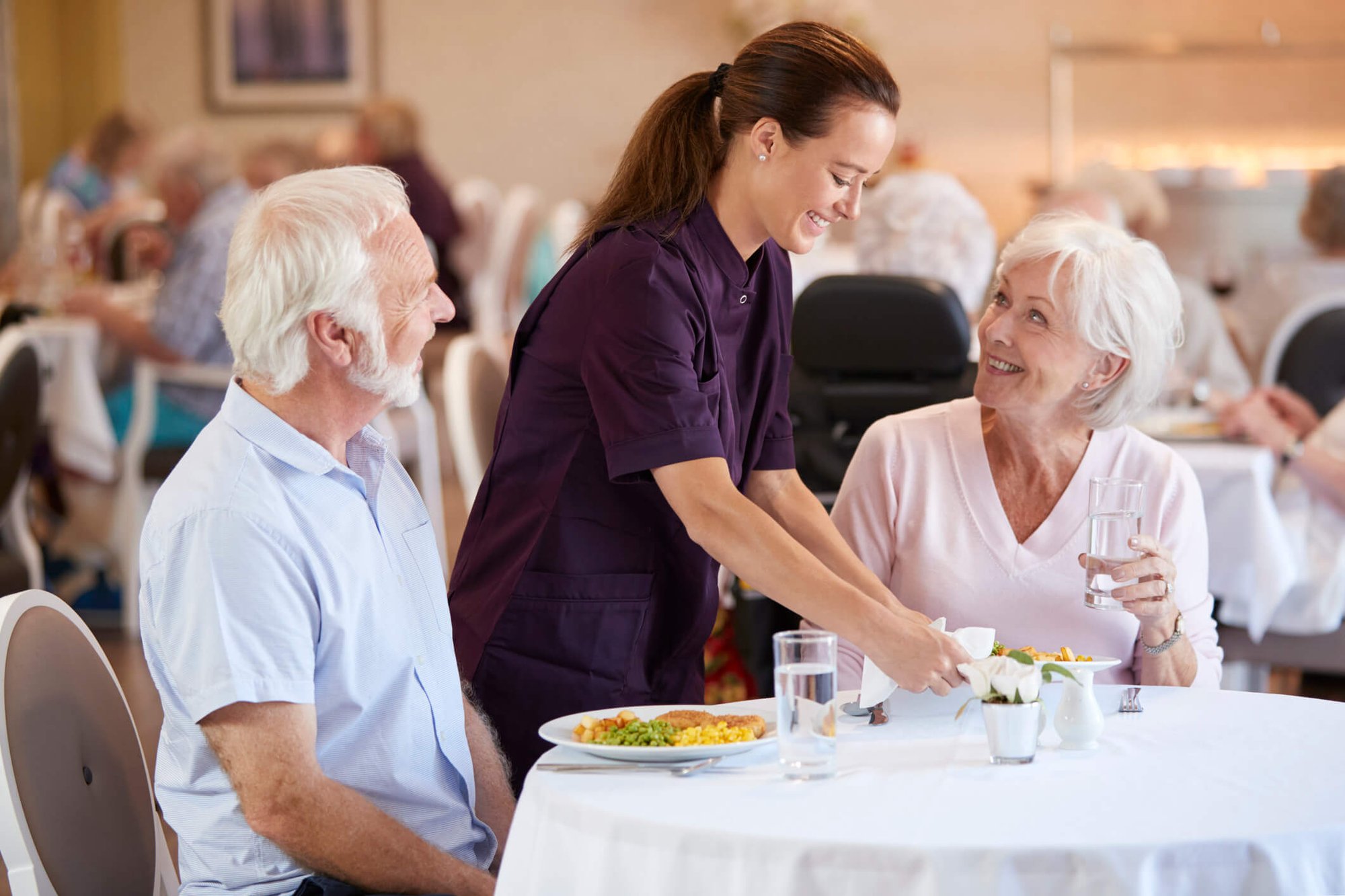 waitress delivering food to a man and woman