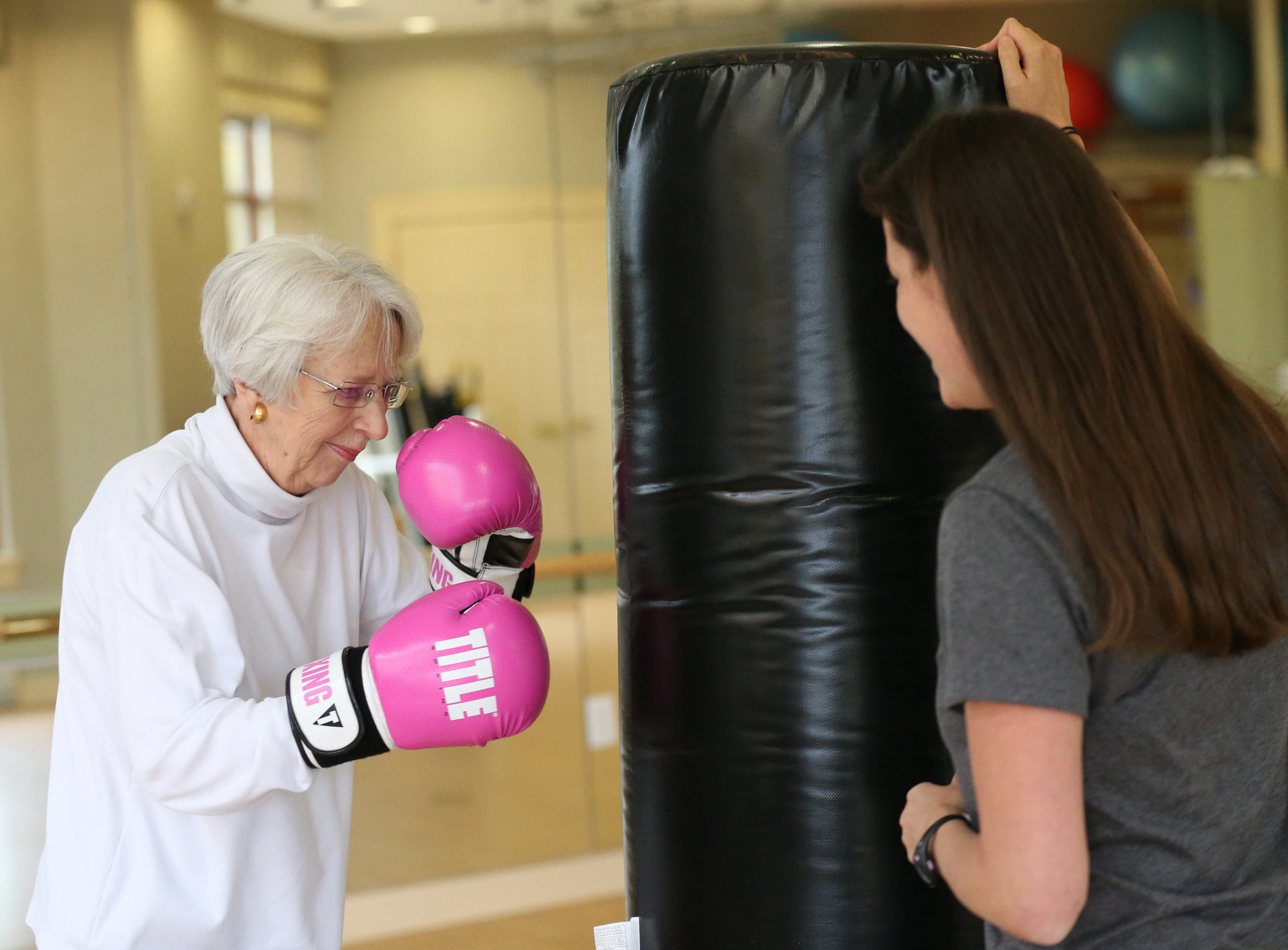Senior woman exercising with instructor