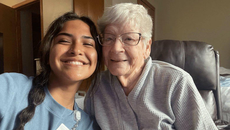 A senior and a young person smiling in a living room