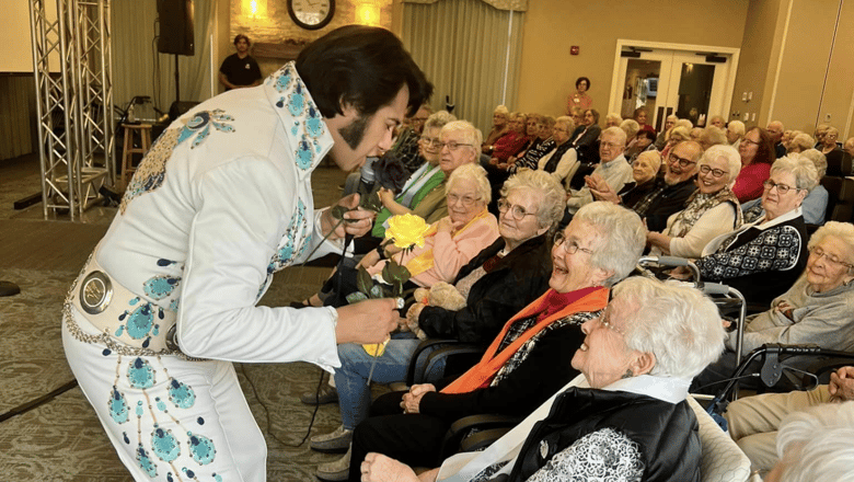 An Elvis impersonator giving a concert to a group of listeners