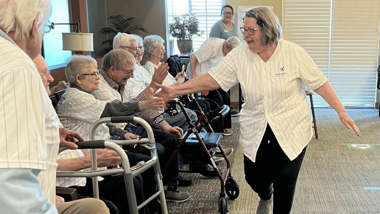 A woman walking along a line of people to give them all high-fives