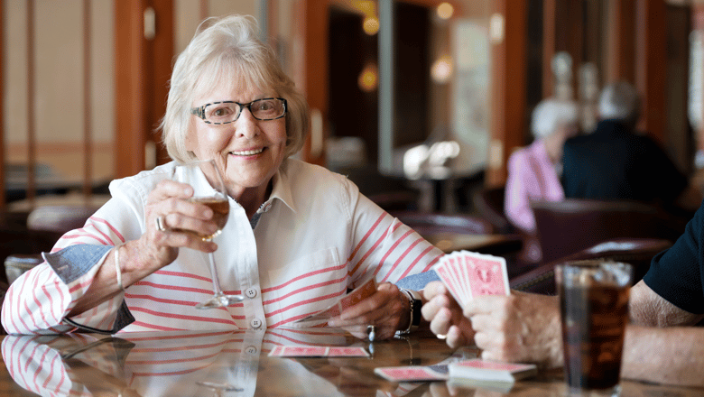 A woman drinking wine and playing cards