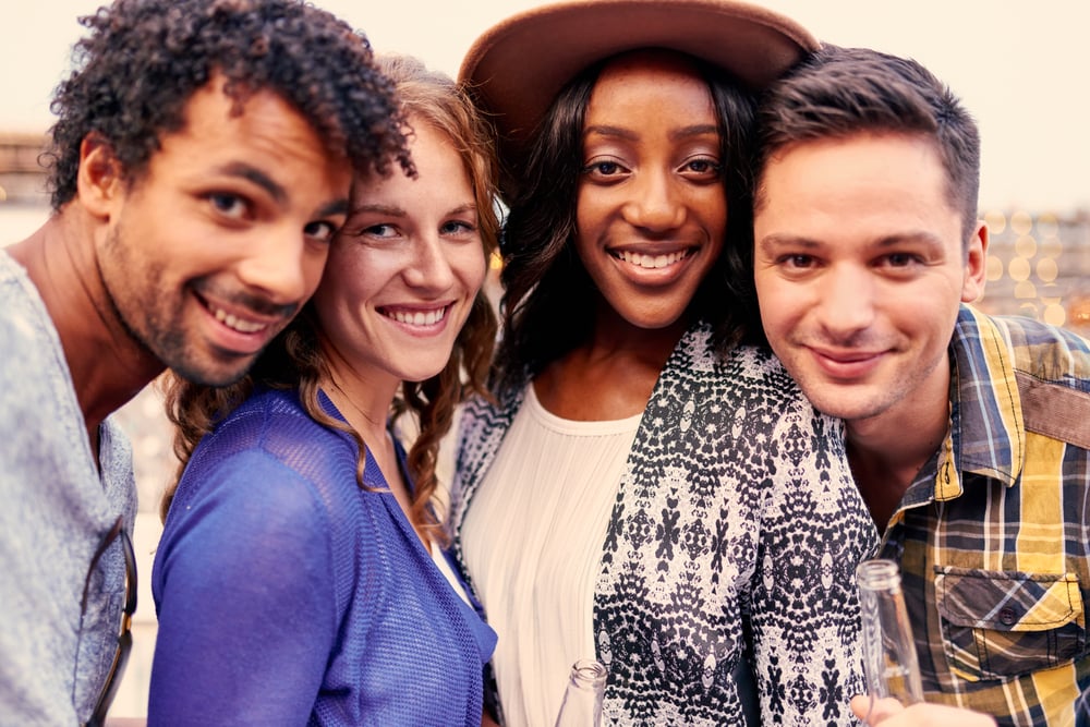 Multi-ethnic millenial group of friends taking a selfie photo with mobile phone on rooftop terrasse at sunset Multi-ethnic millenial group of friends taking a selfie photo with mobile phone on rooftop terrasse at sunset