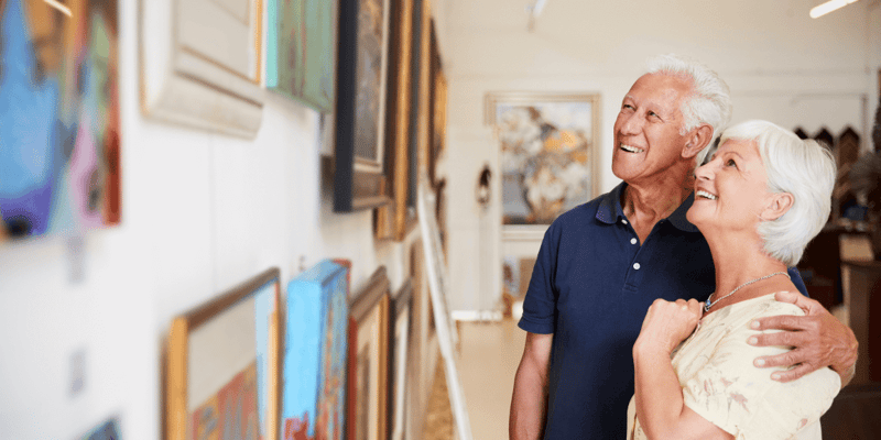 senior couple at an art gallery looking at art on the walls