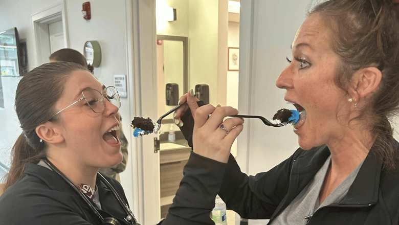 Two team members feeding each other cake