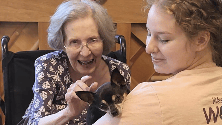 A team member and a resident petting a dog