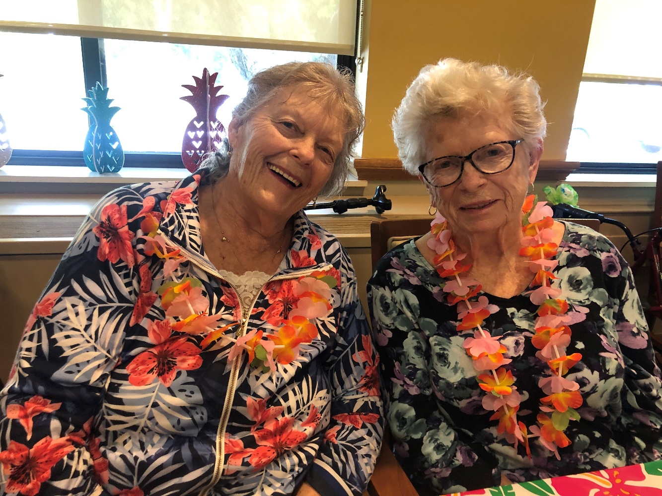 two senior woman residents smiling at event