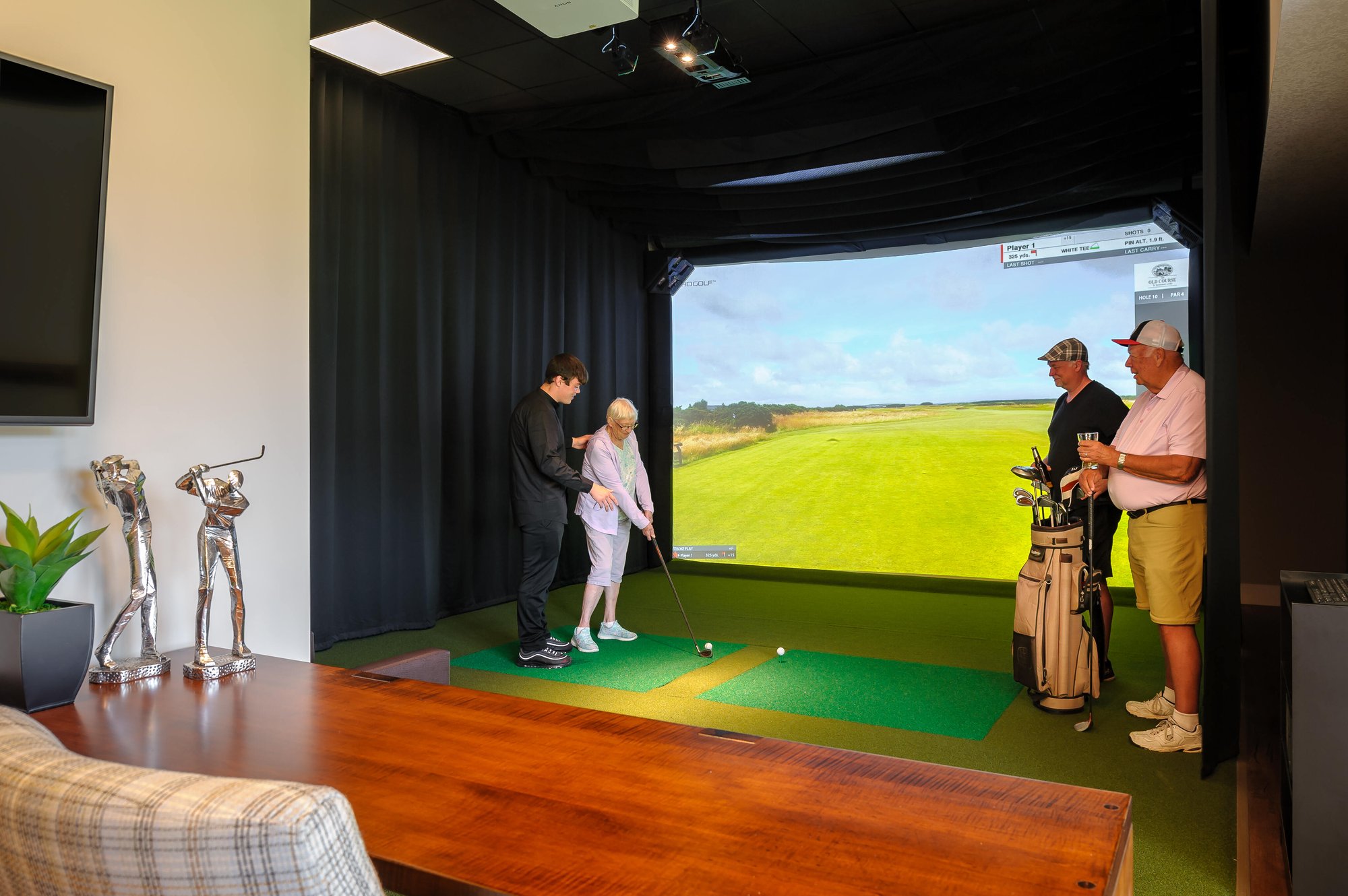 senior friends at indoor golf simulator