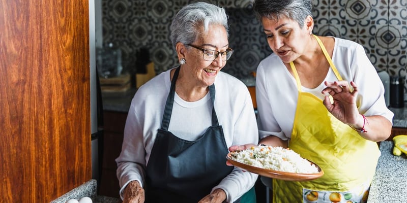 Happy senior mother and daughter preparing a meal together