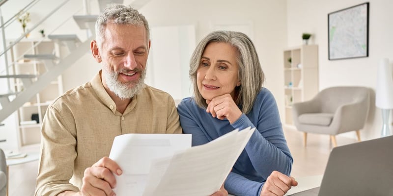 A senior couple looking over financial paperwork together.