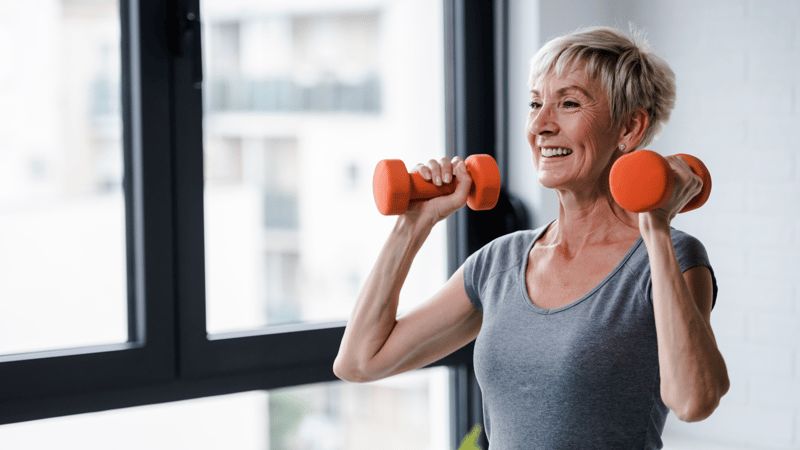 A woman in her 60s lifting weights.