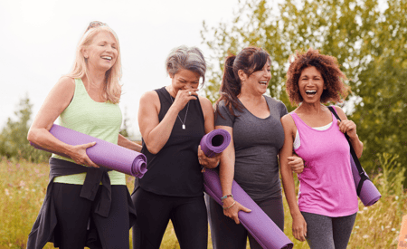 four senior women with yoga mats