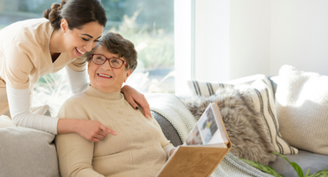 older adult woman showing young woman photo album