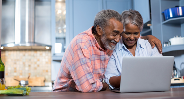A senior couple using a laptop to plan for their future care. 