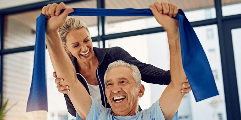 A physical therapist helping a senior man stretch in short-term rehabilitation.