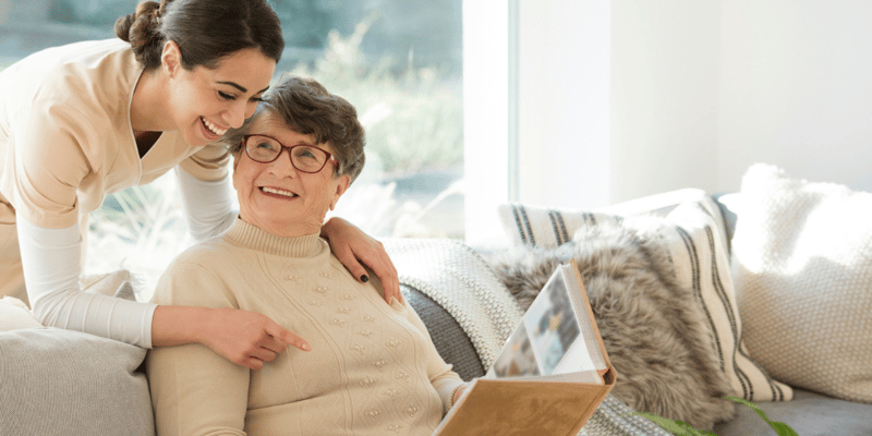 older adult woman showing young woman photo album