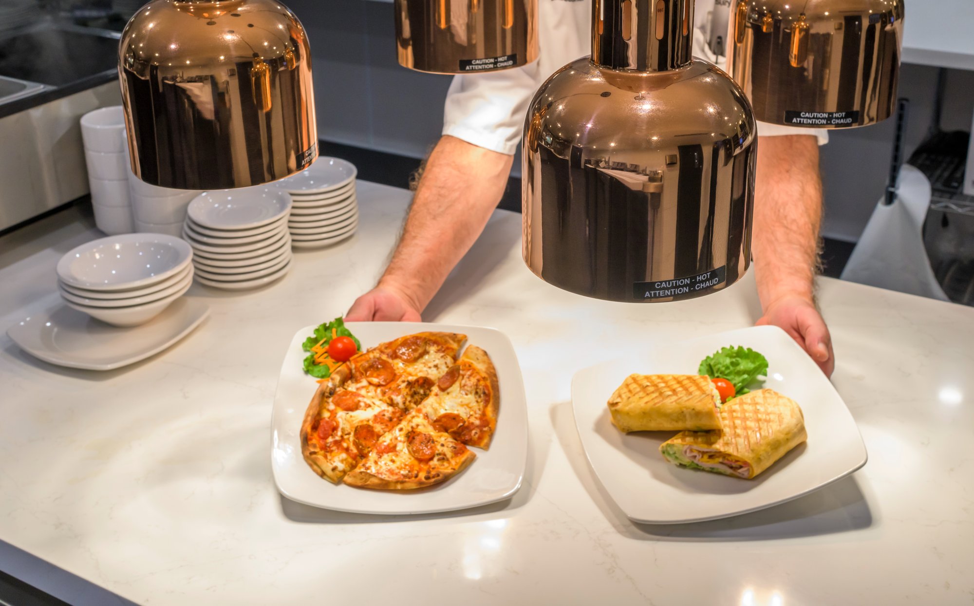 chef serving plated food to waiters