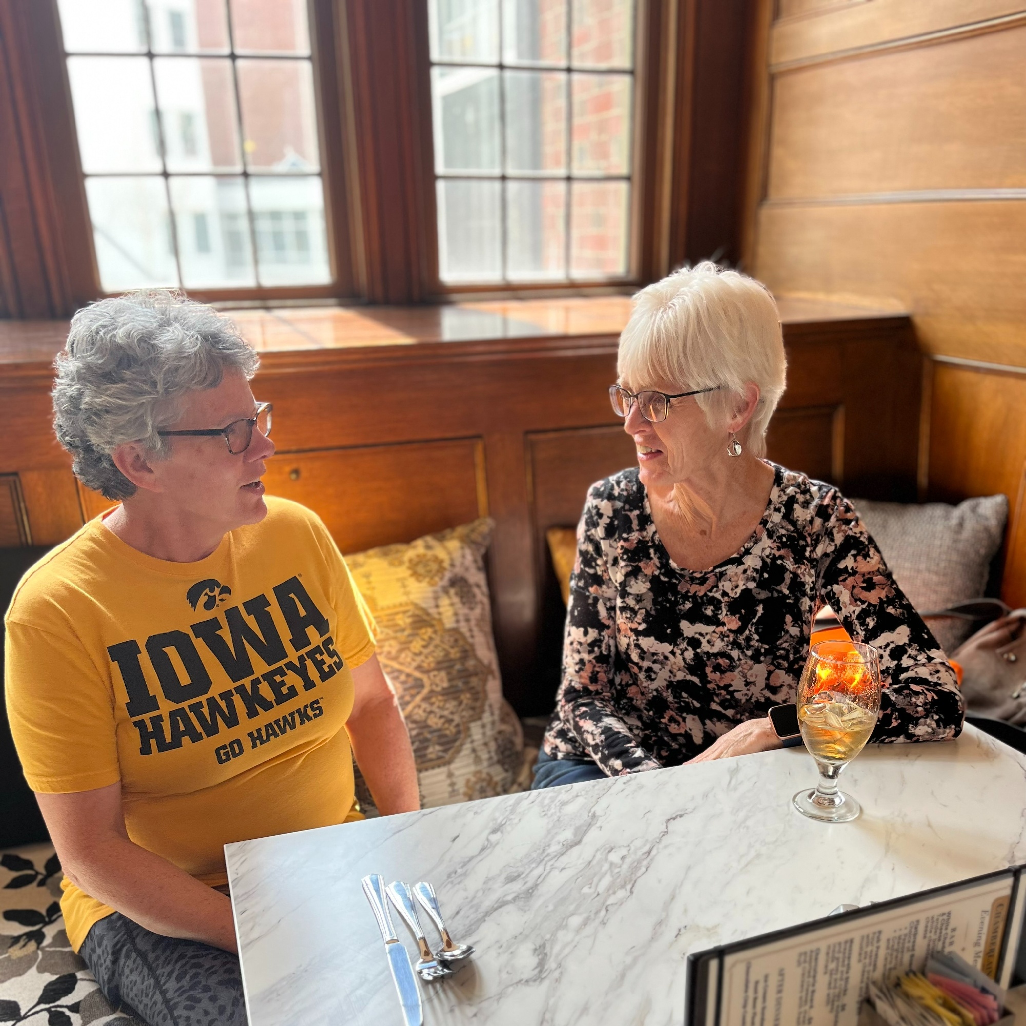 two senior women talking at lunch