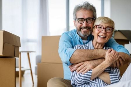Senior couple smiling around boxes