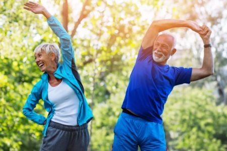 senior couple stretching in park