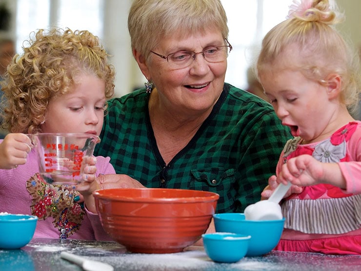 Adult day participant with children baking