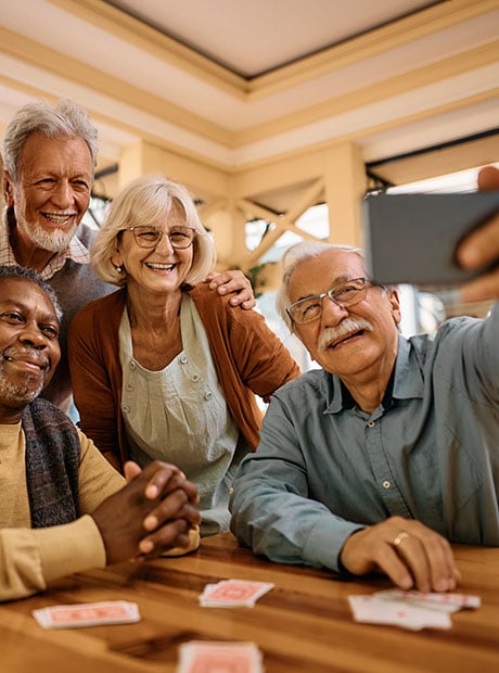 Cheerful senior have fun while taking selfie at retirement community